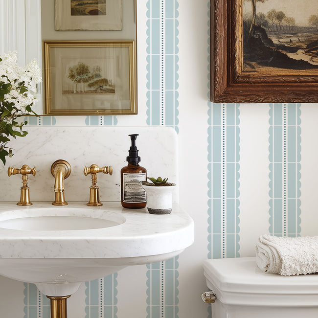 Bathroom with a sink, toiletries, and decorative elements against a striped stencil wall.