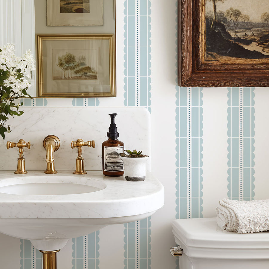 Bathroom with a sink, toiletries, and decorative elements against a striped stencil wall.