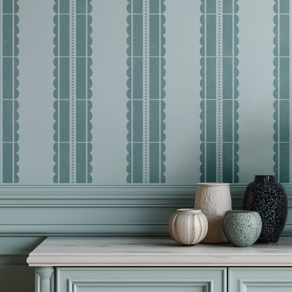 Decorative wall stencil with vertical patterned stripes and a row of ceramic vases on a surface.
