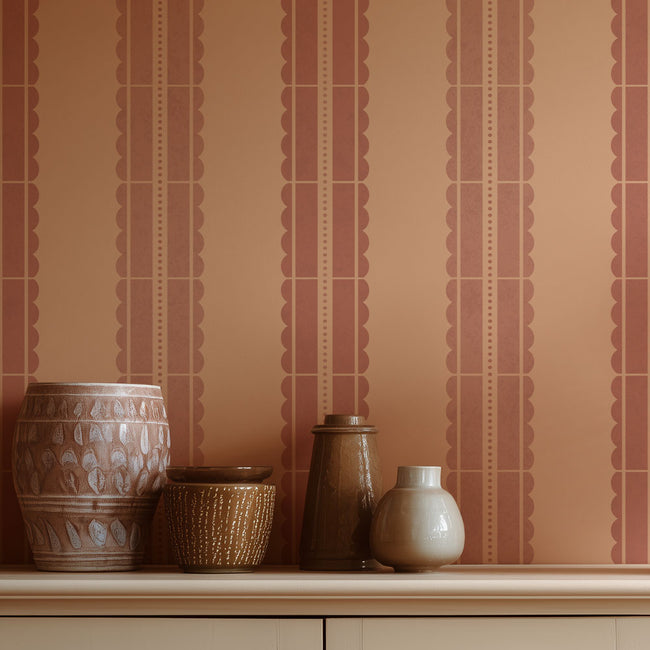 Decorative vases on a shelf against a striped stenciled wall.